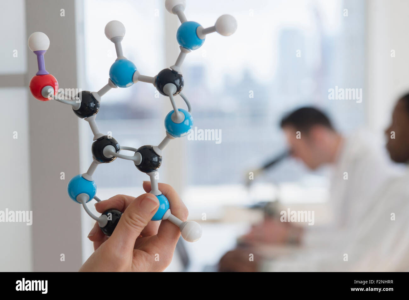 Close up of scientist holding molecular model in lab Stock Photo