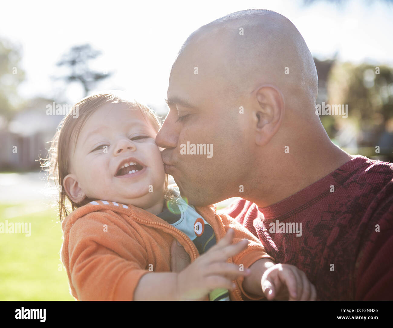 Close up of Hispanic father kissing cheek of son outdoors Stock Photo