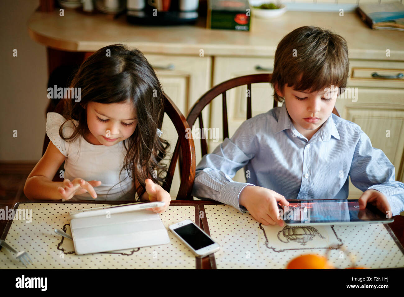 Caucasian brother and sister using digital tablets Stock Photo - Alamy