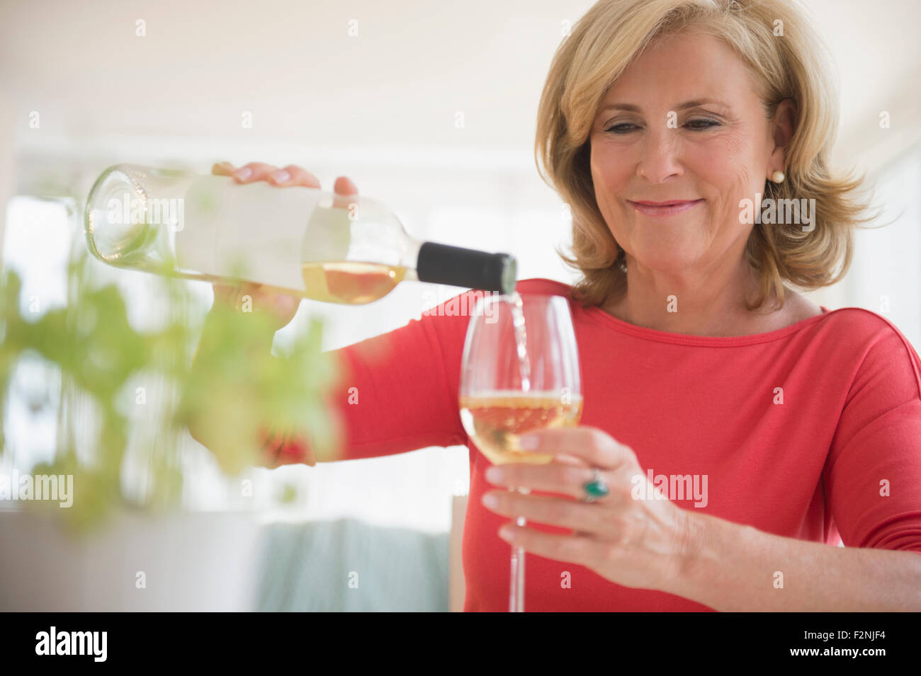 Caucasian woman pouring glass of white wine Stock Photo