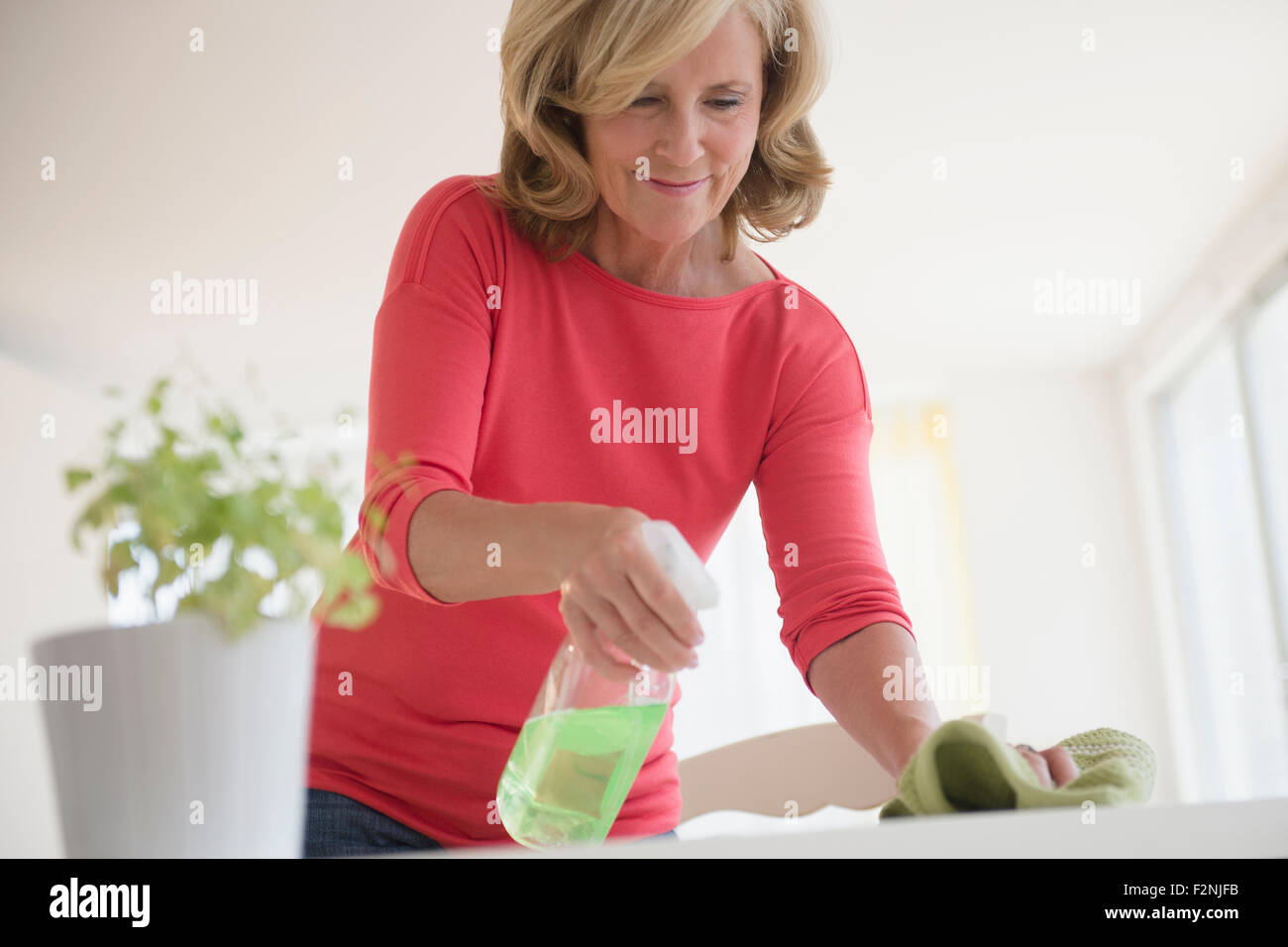 Caucasian woman cleaning table Stock Photo