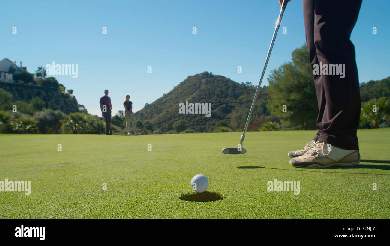 Caucasian woman putting on golf course Stock Photo