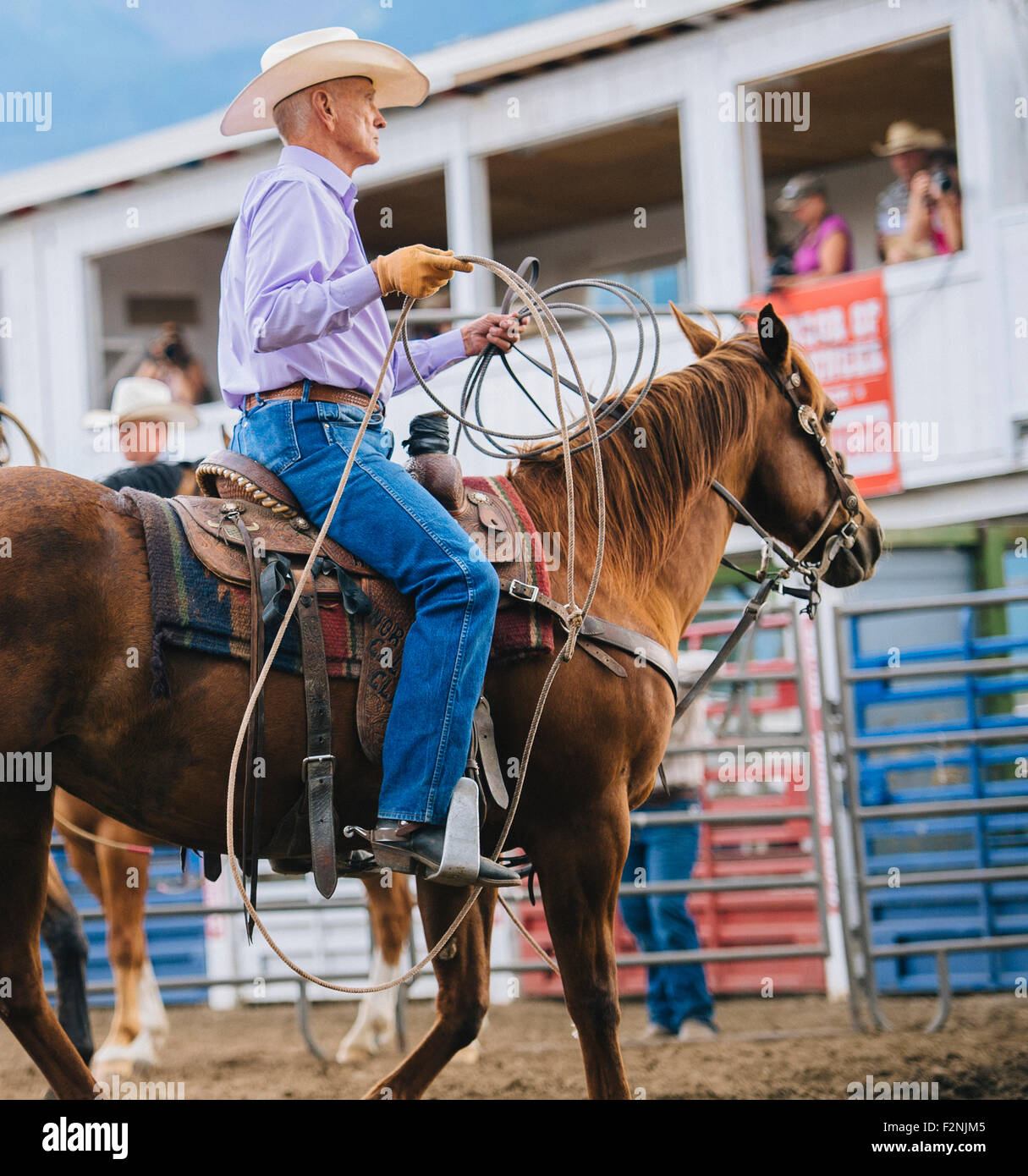 Caucasian cowboy riding horse in rodeo Stock Photo