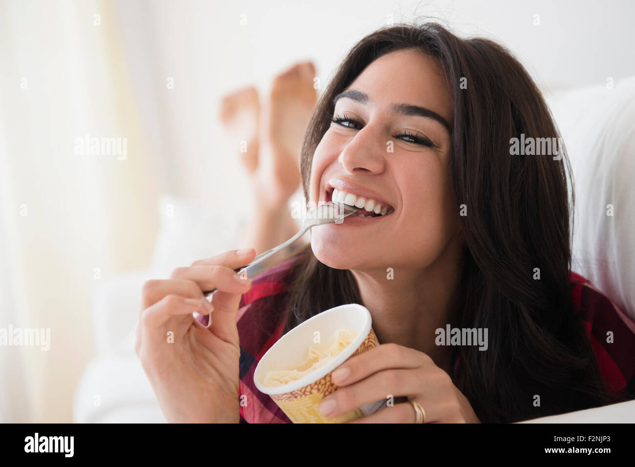 Close up of woman eating ice cream on sofa Stock Photo