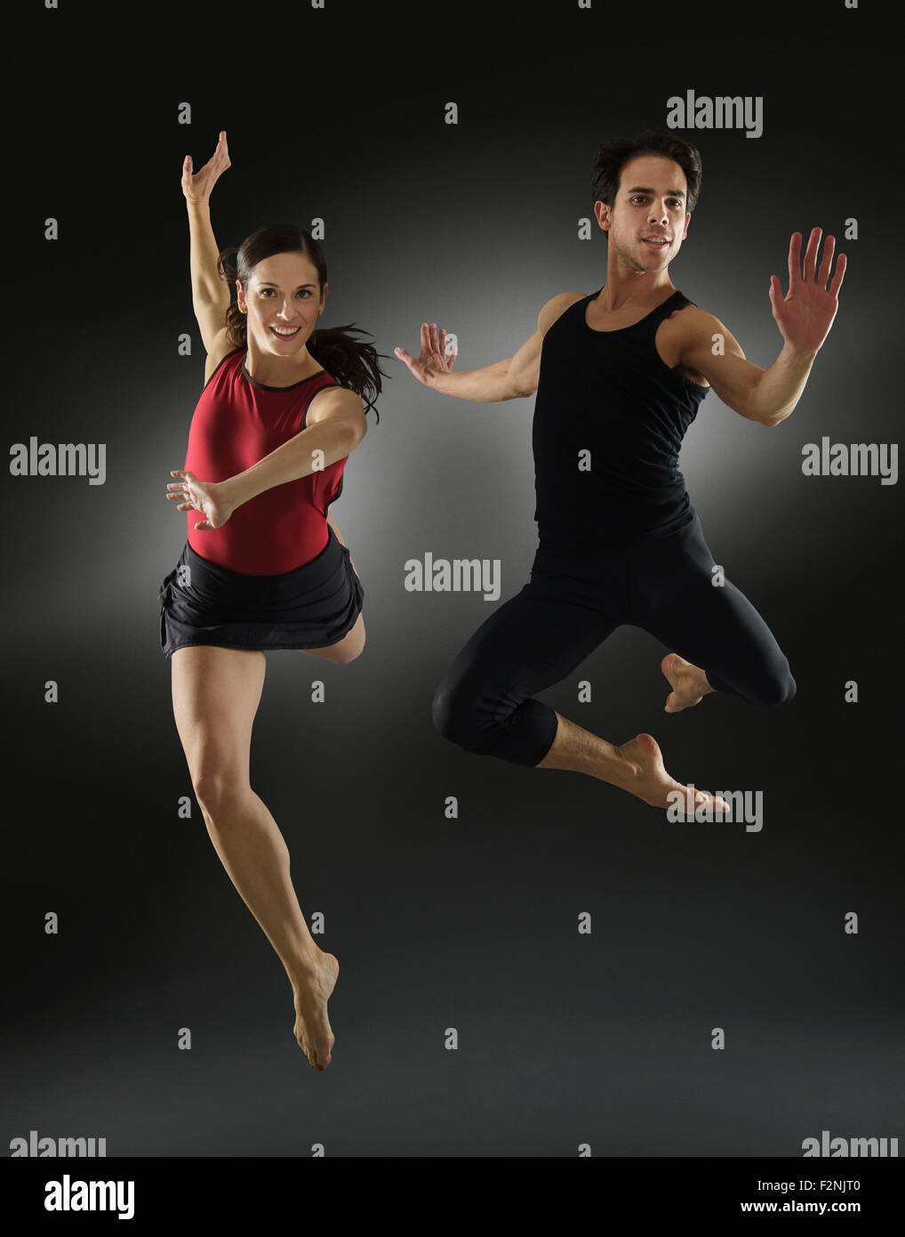 Hispanic dancers leaping in mid-air Stock Photo