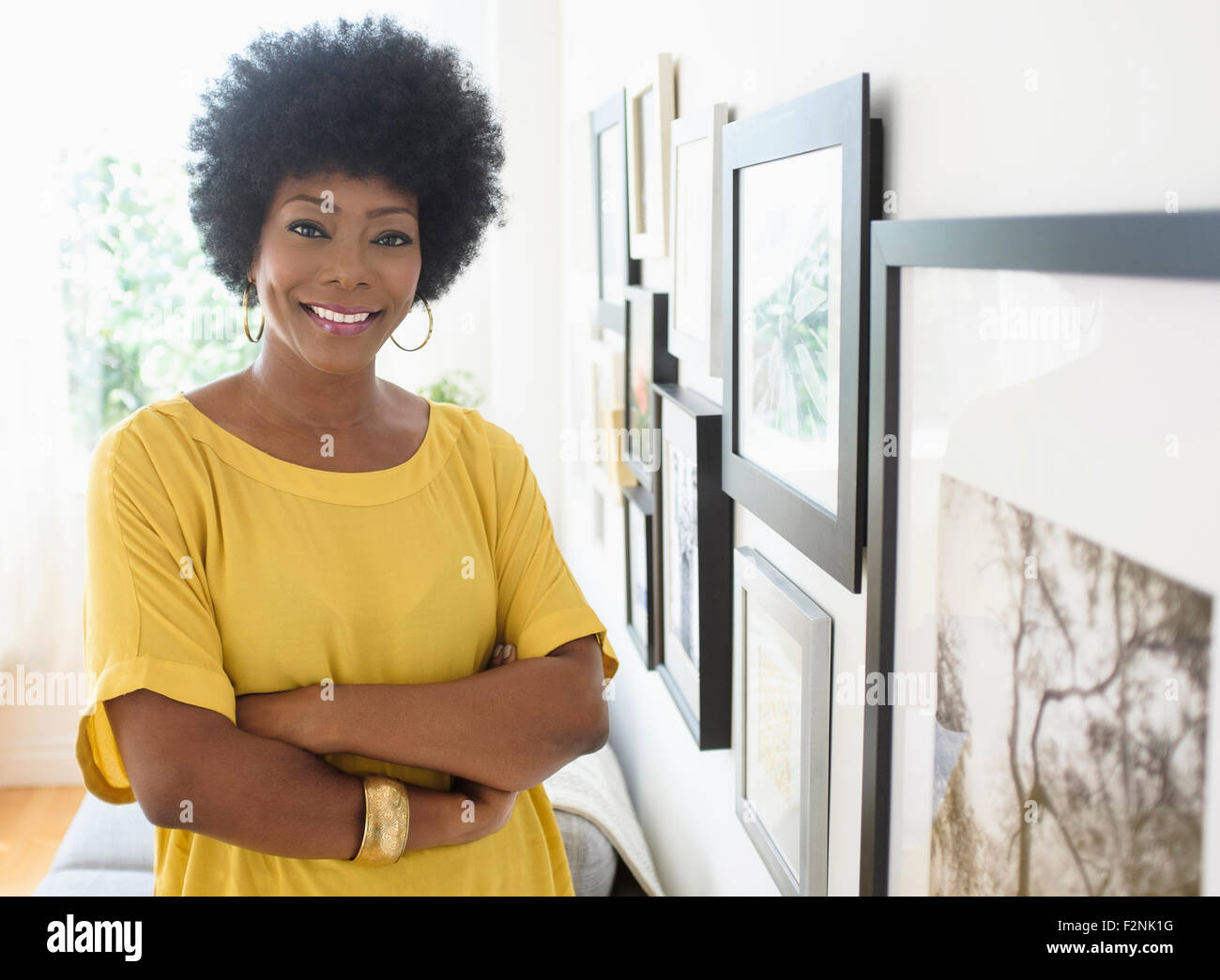African American woman standing near pictures on wall Stock Photo