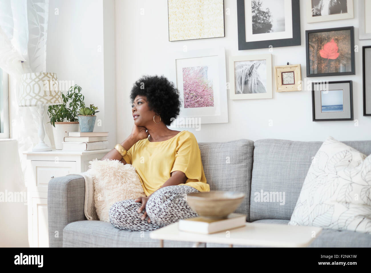 African American woman relaxing on sofa Stock Photo - Alamy