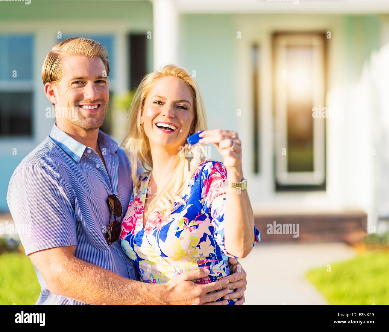Caucasian couple holding keys outside new home Stock Photo - Alamy