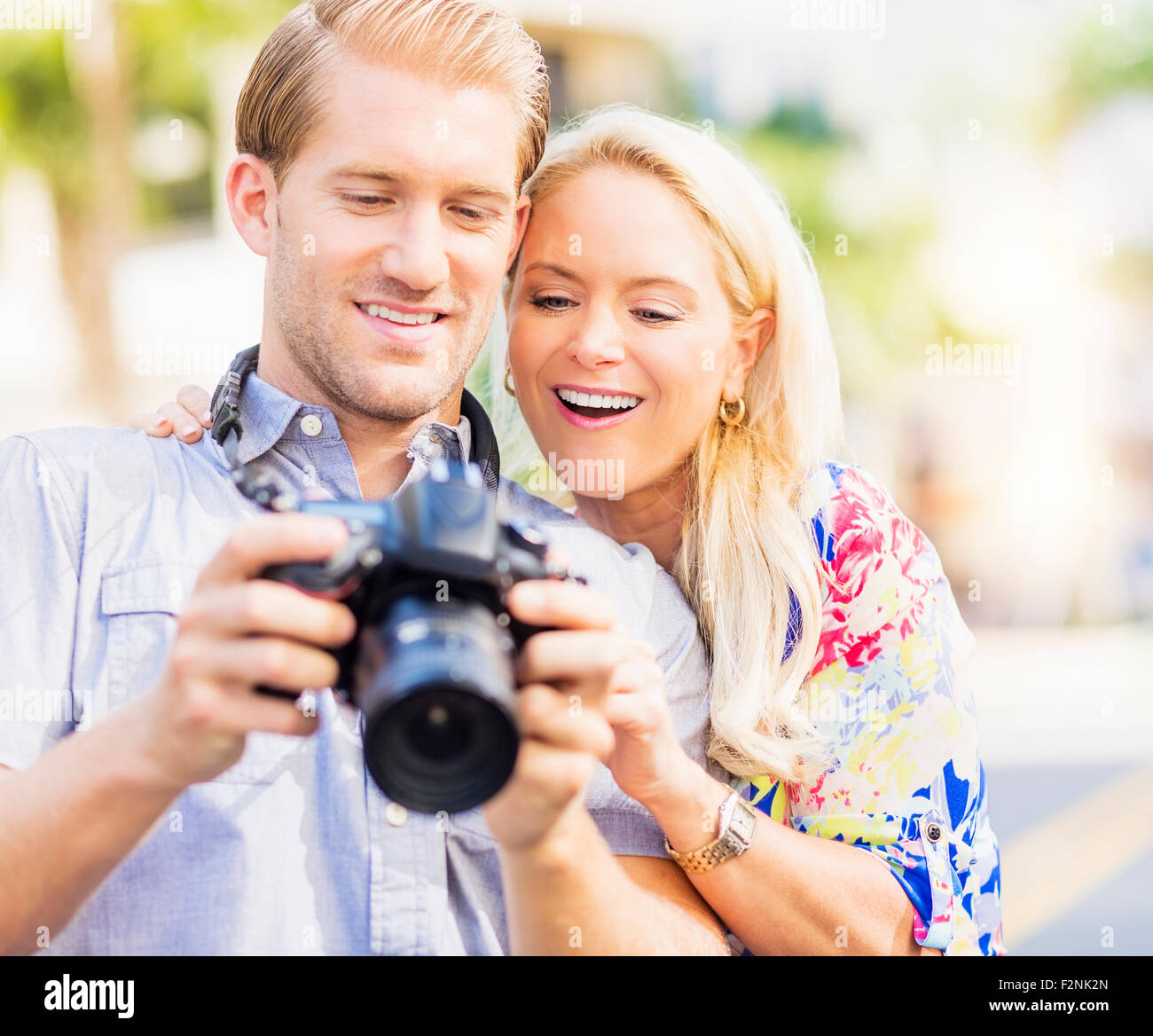 Caucasian couple reviewing digital photographs on camera Stock Photo