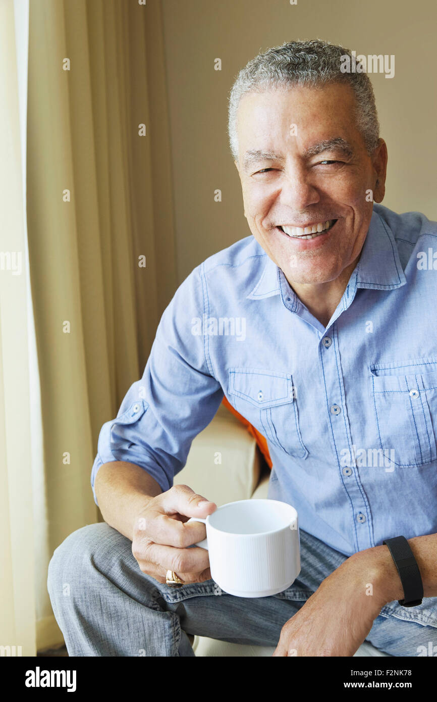 Older Black man drinking coffee Stock Photo