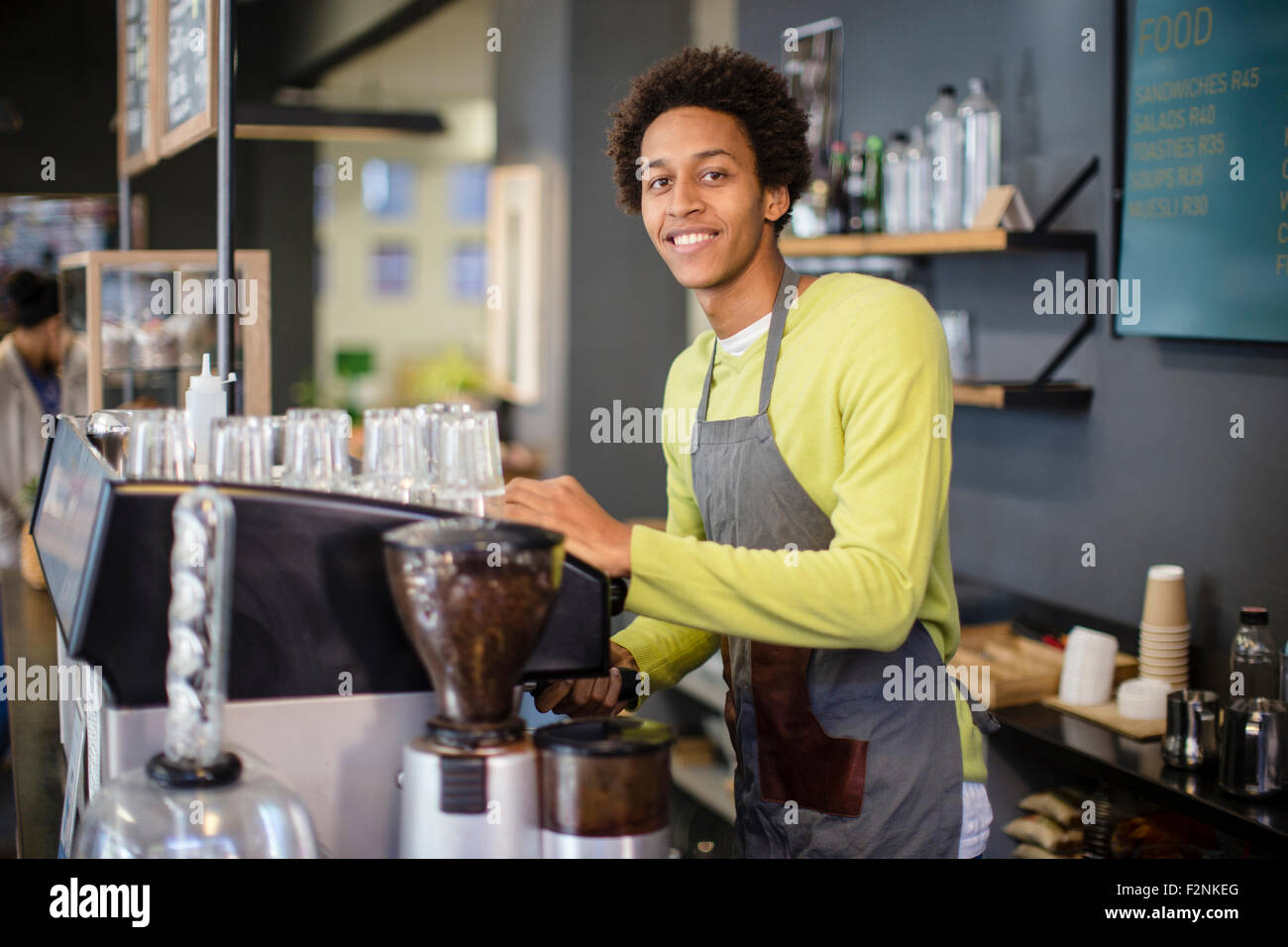 Mixed race barista working in coffee shop Stock Photo