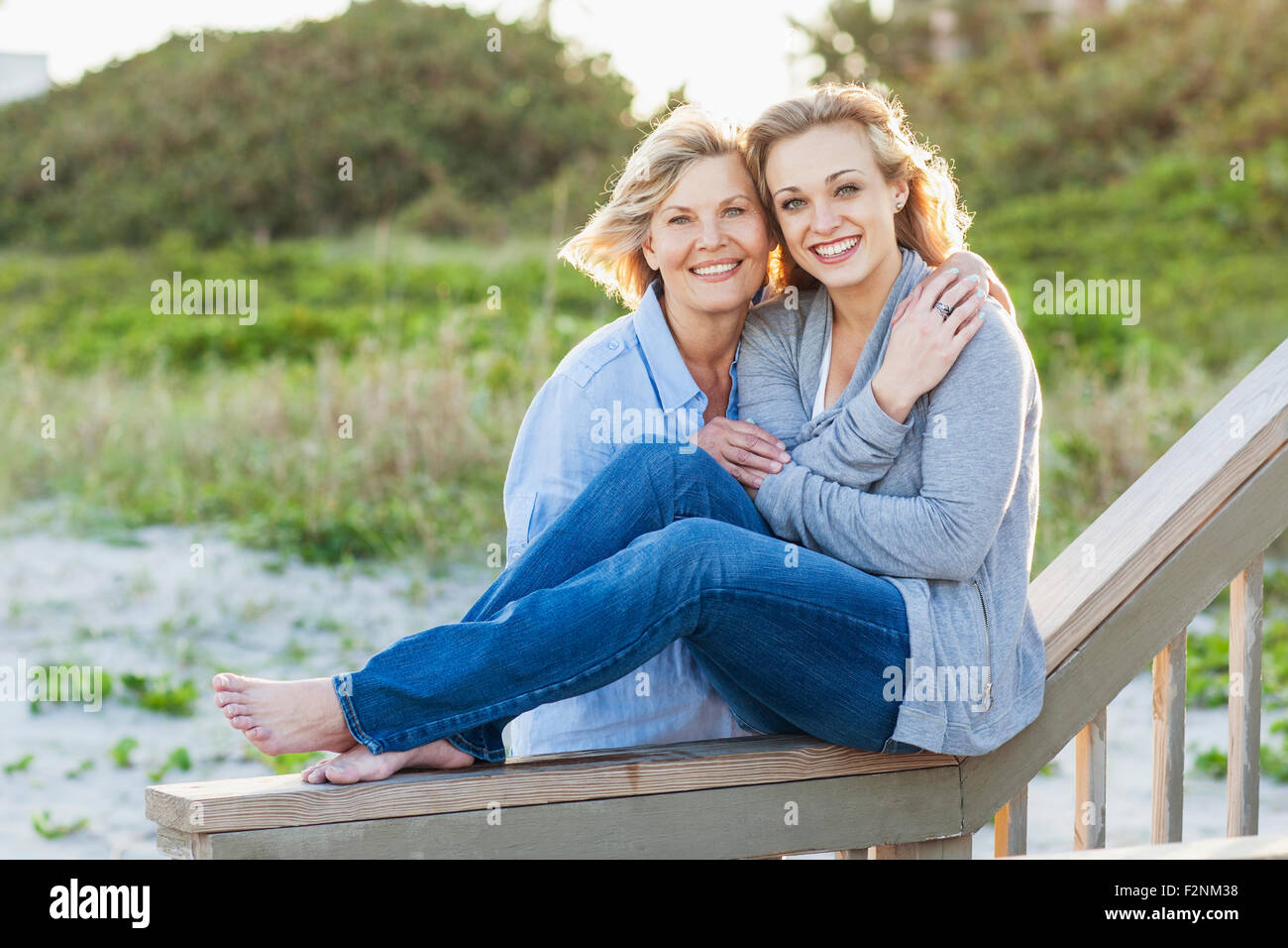 Caucasian mother and daughter hugging on beach Stock Photo