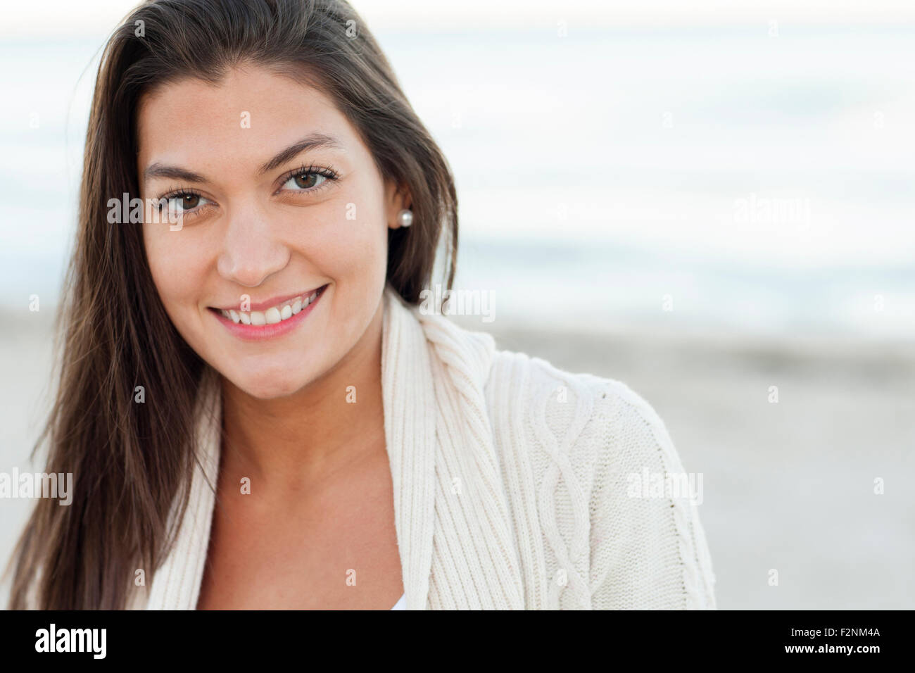 Hispanic woman smiling on beach Stock Photo