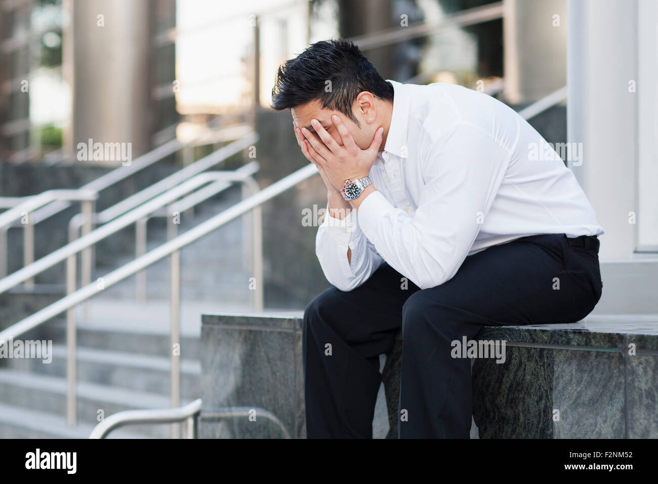 Stressed mixed race businessman covering his face Stock Photo