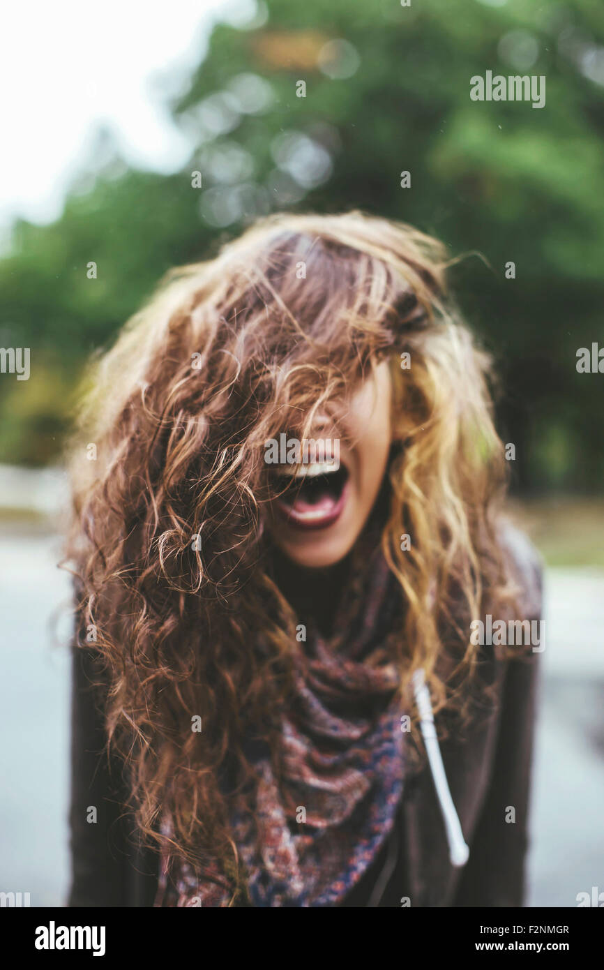 Shouting Middle Eastern woman tossing her hair outdoors Stock Photo