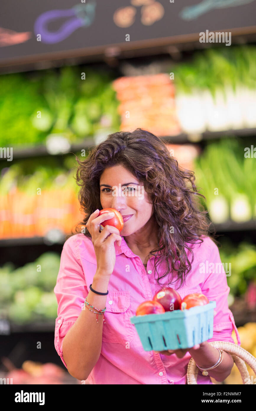 Hispanic woman checking produce at grocery store Stock Photo
