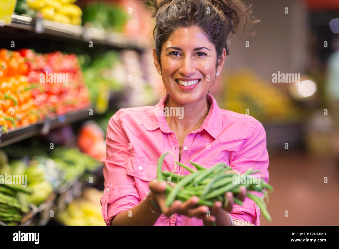 Hispanic woman holding vegetables at grocery store Stock Photo