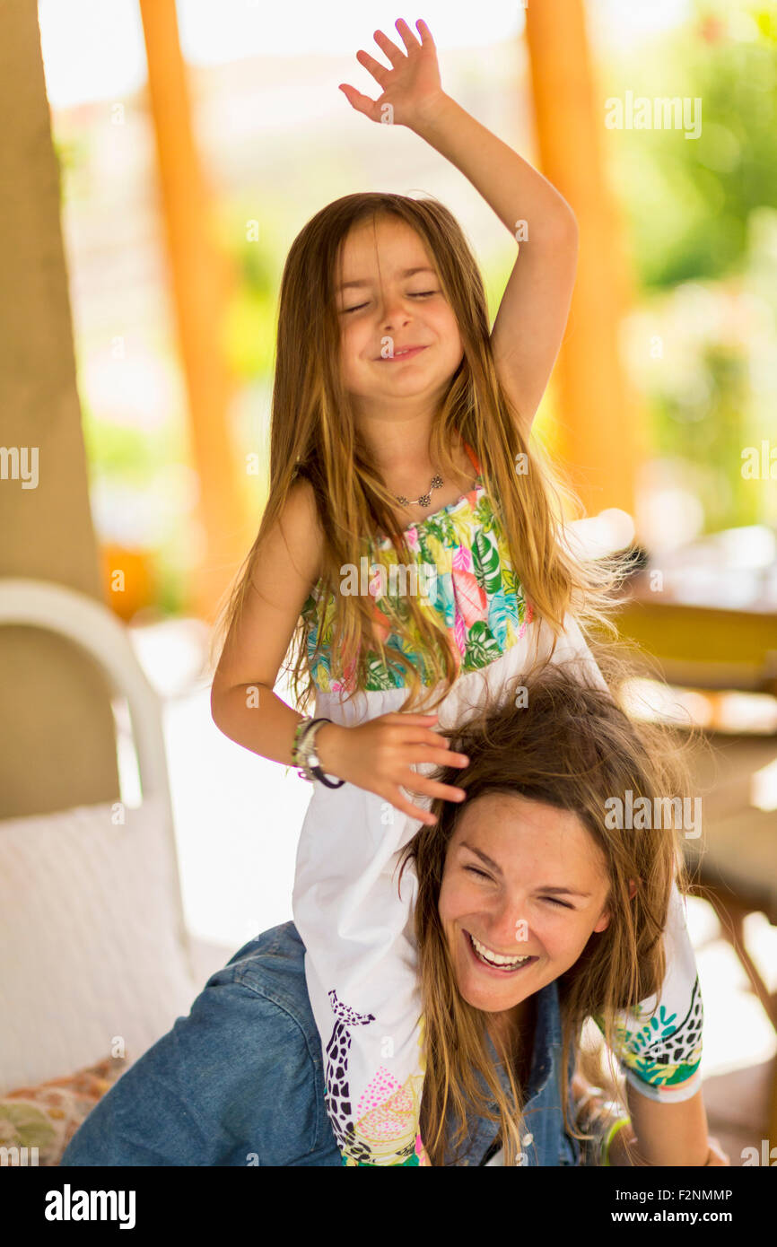 Mother carrying daughter on shoulders Stock Photo