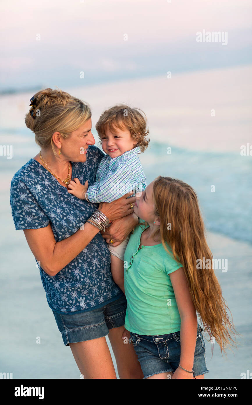 Caucasian mother and children playing on beach Stock Photo