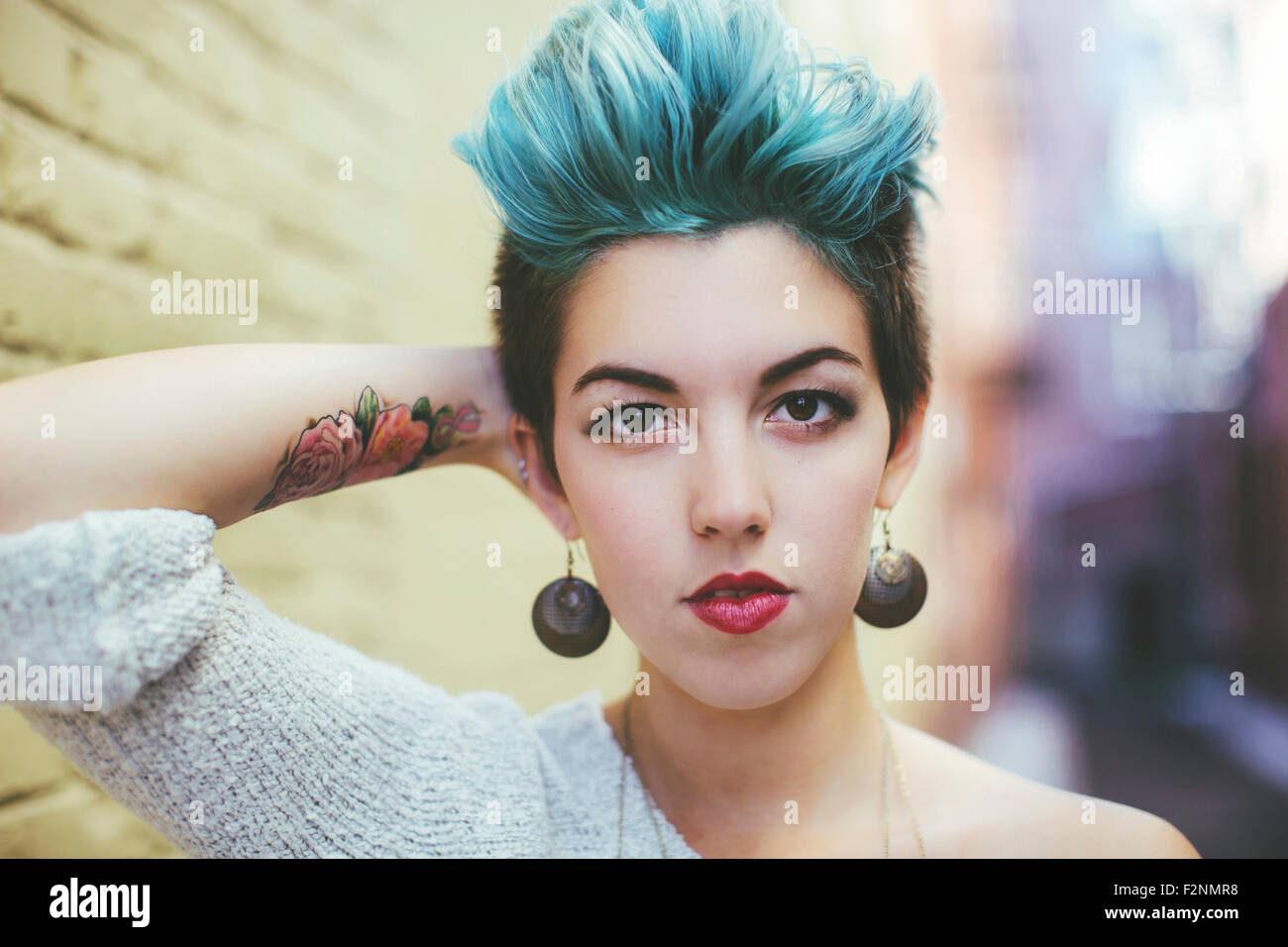 Stylish Caucasian woman with earrings and dyed hair Stock Photo