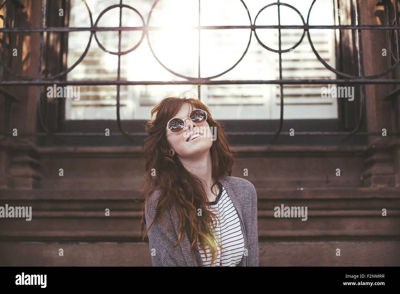 Caucasian woman standing under window Stock Photo