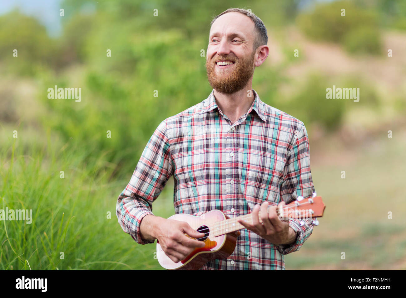 Caucasian man playing ukulele outdoors Stock Photo