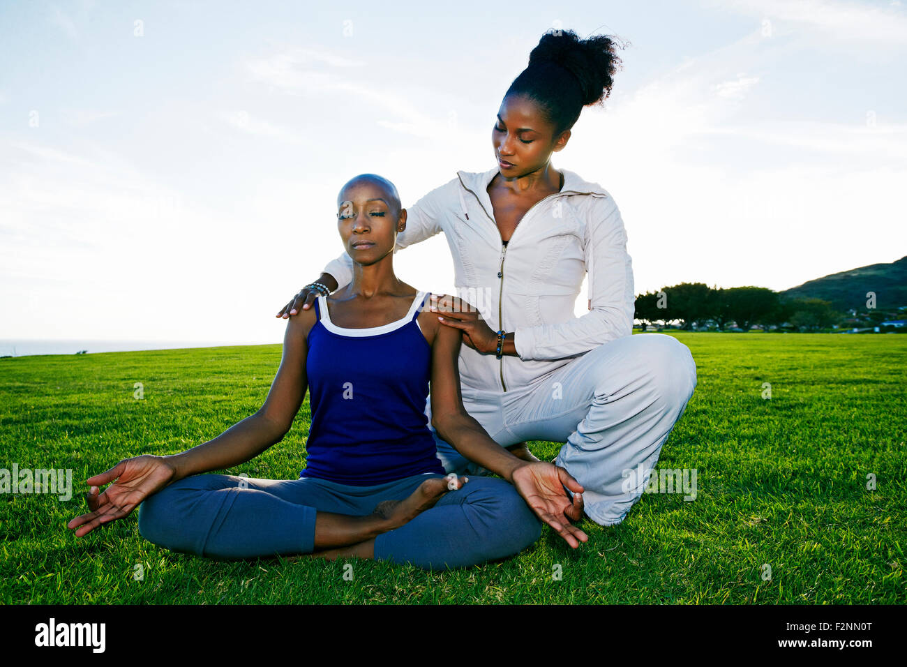 Woman practicing yoga with teacher in park Stock Photo
