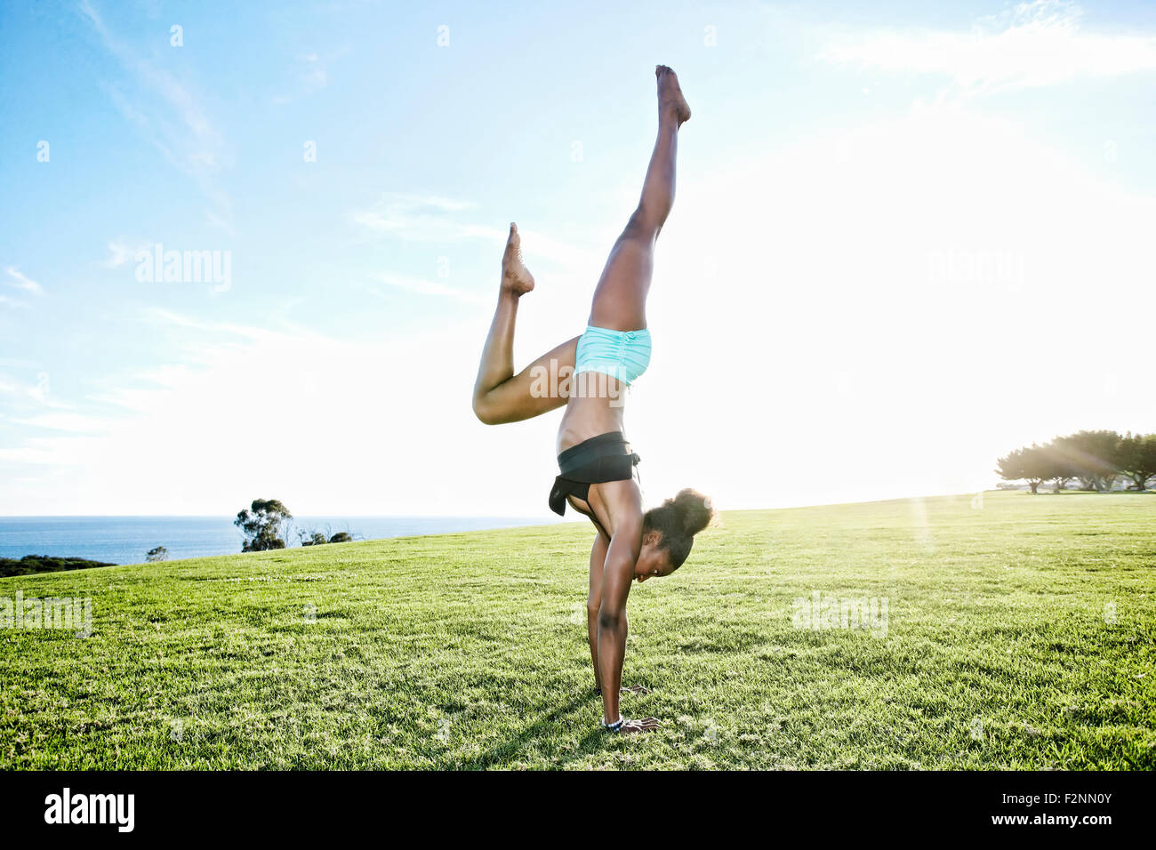 African American woman practicing yoga in park Stock Photo