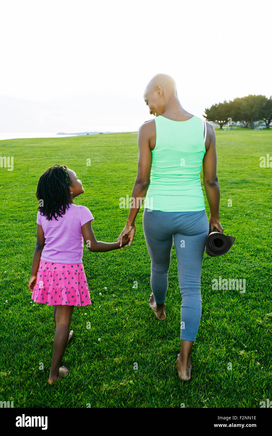 Mother and daughter holding hands in park Stock Photo