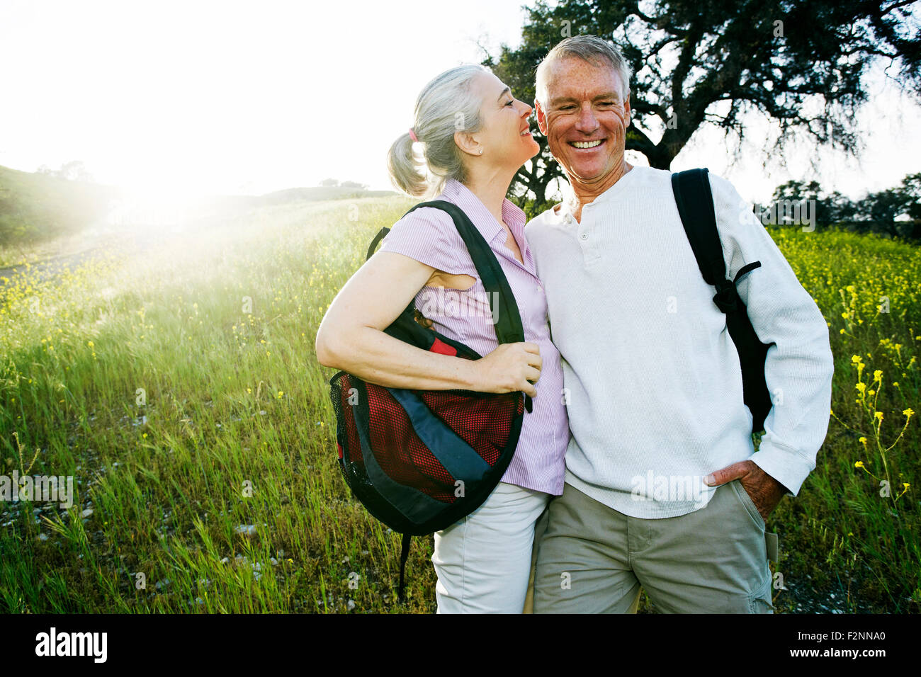 Caucasian couple kissing in tall grass Stock Photo