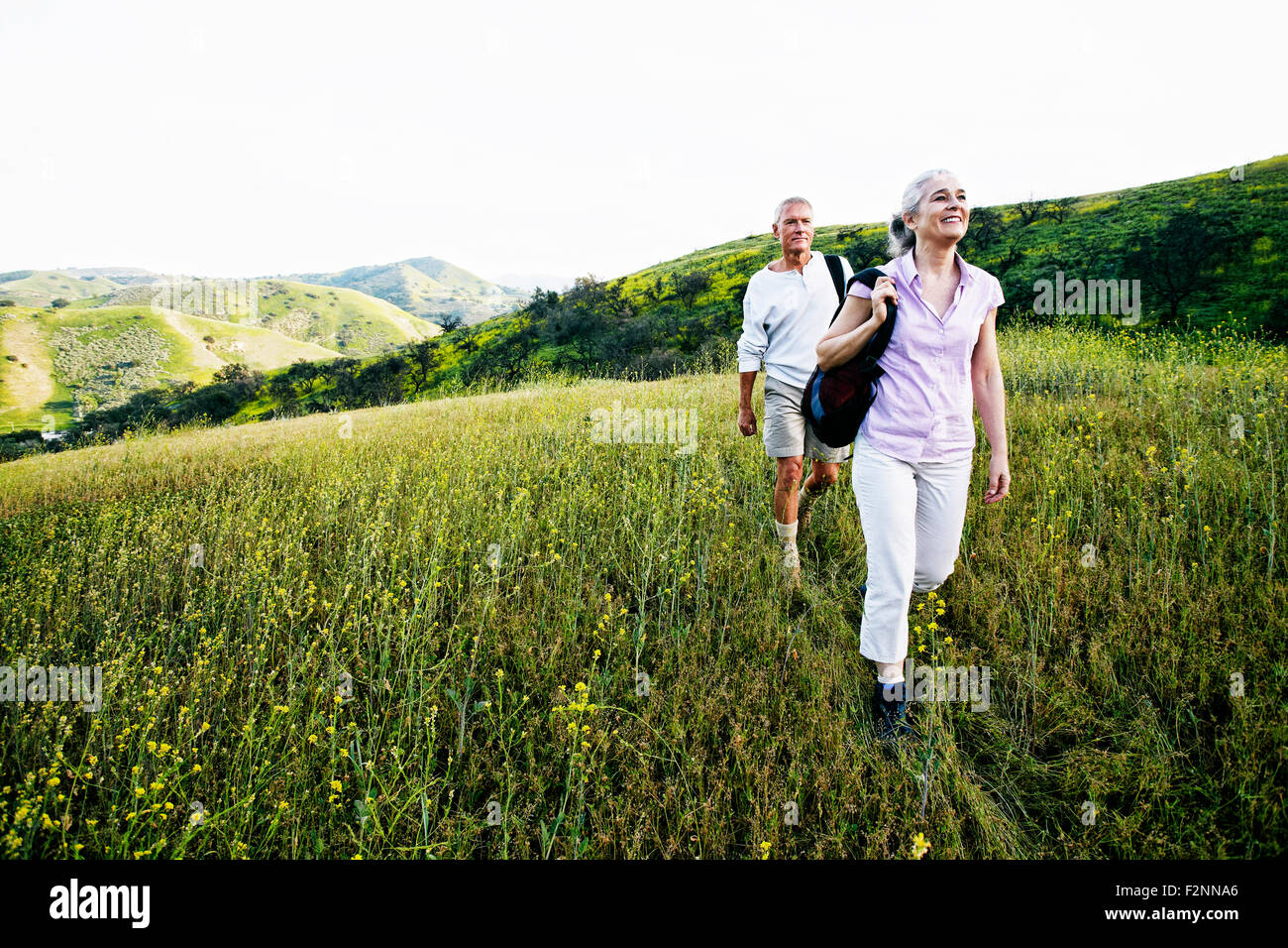 Caucasian couple hiking on hillside Stock Photo