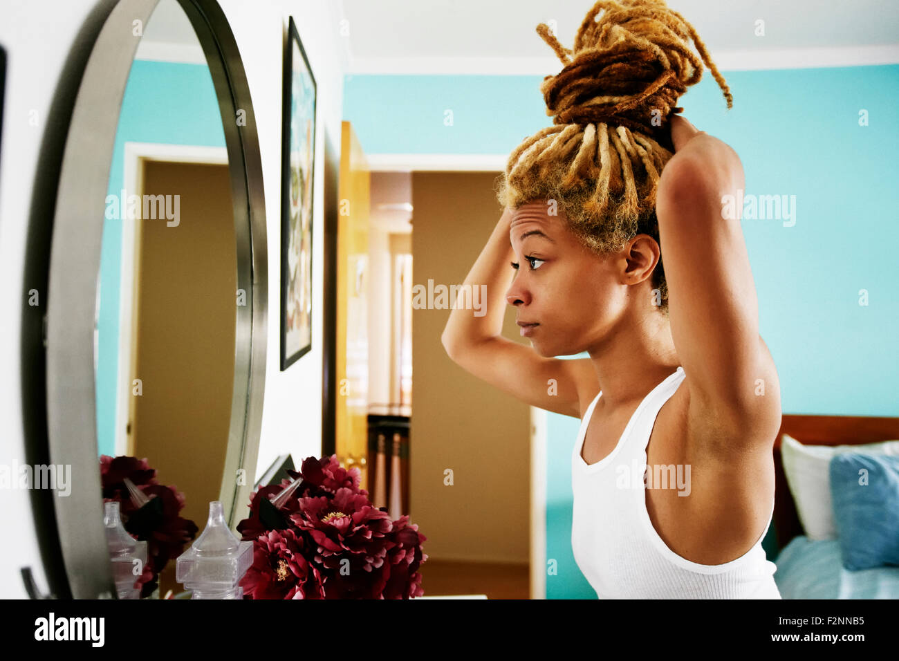 Black woman examining herself in mirror Stock Photo