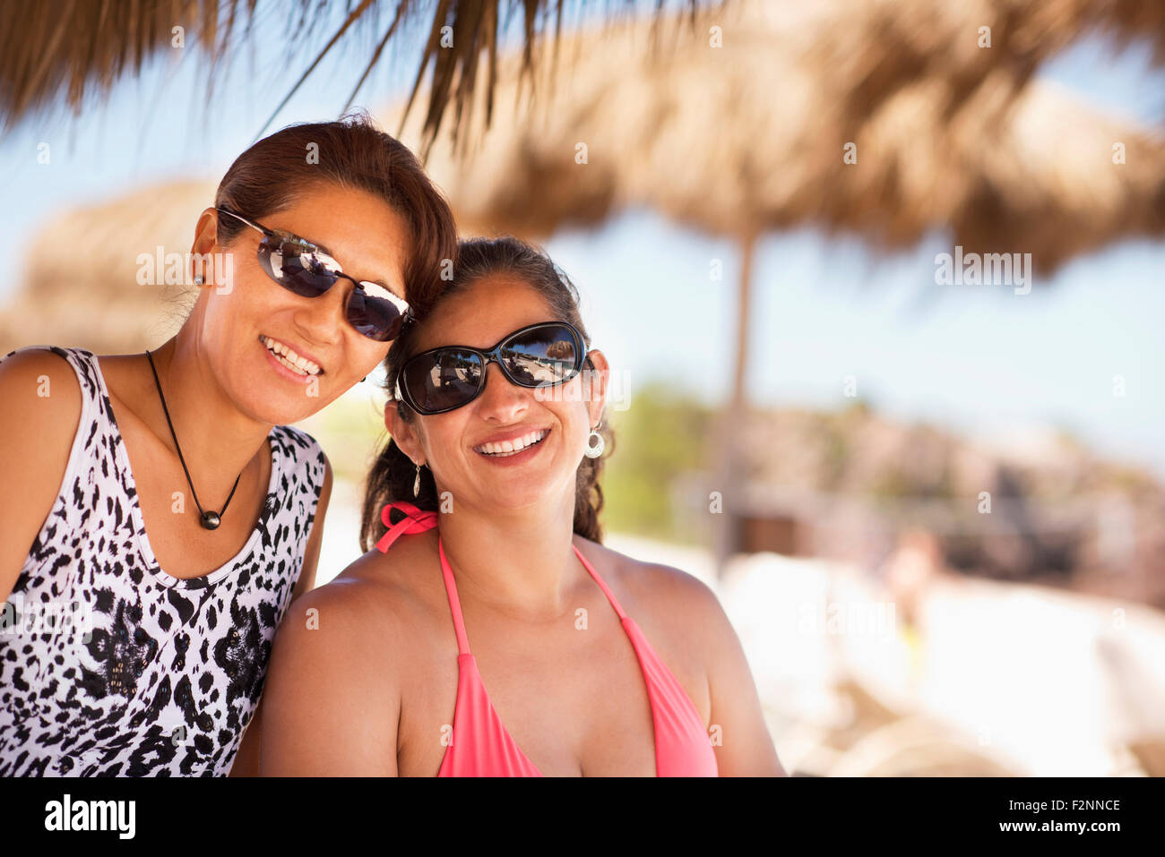 Women wearing sunglasses on tropical beach Stock Photo