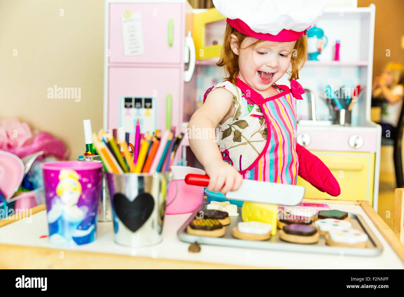 Caucasian girl playing with toy kitchen Stock Photo