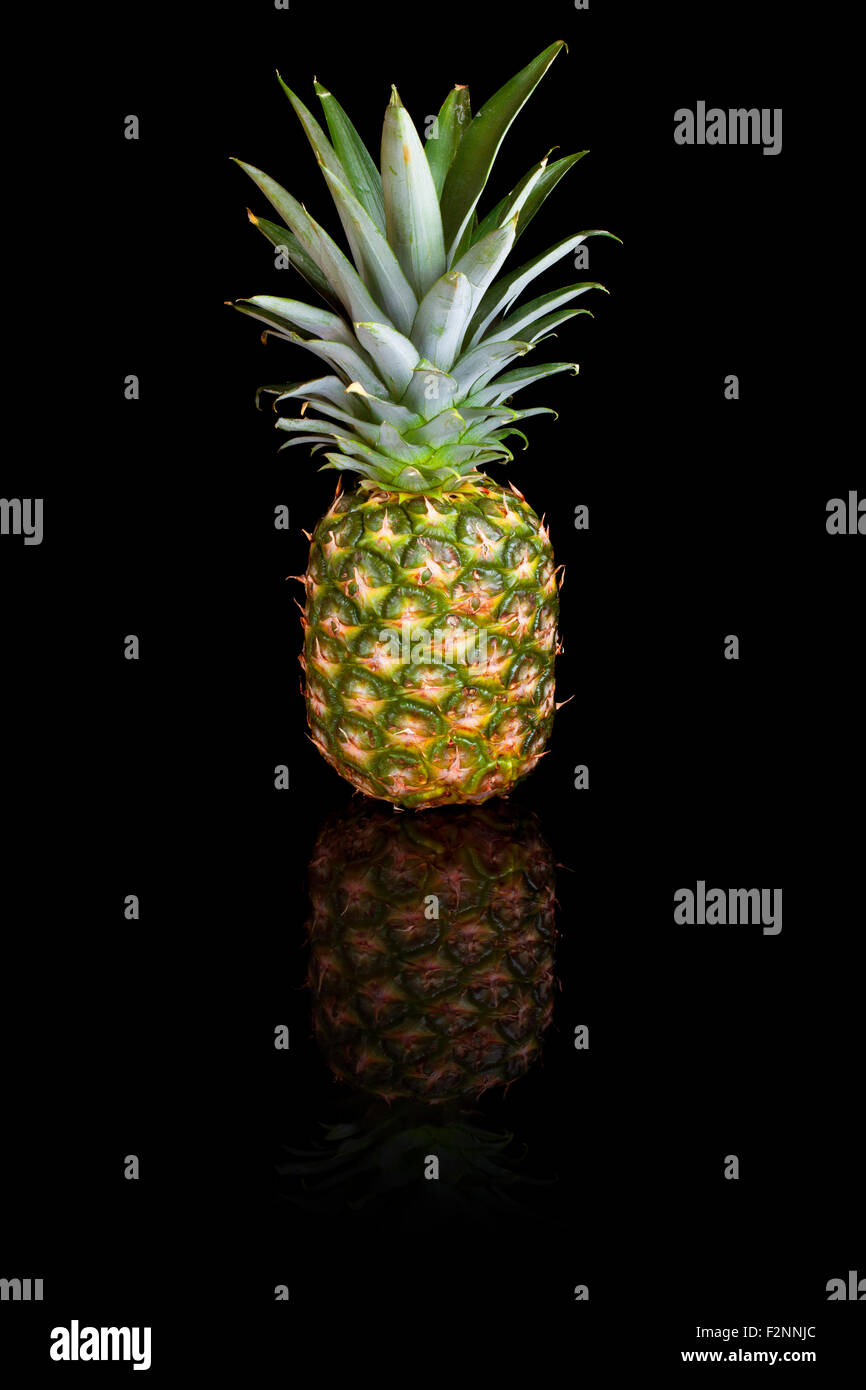 A pineapple on a black reflective background. Stock Photo