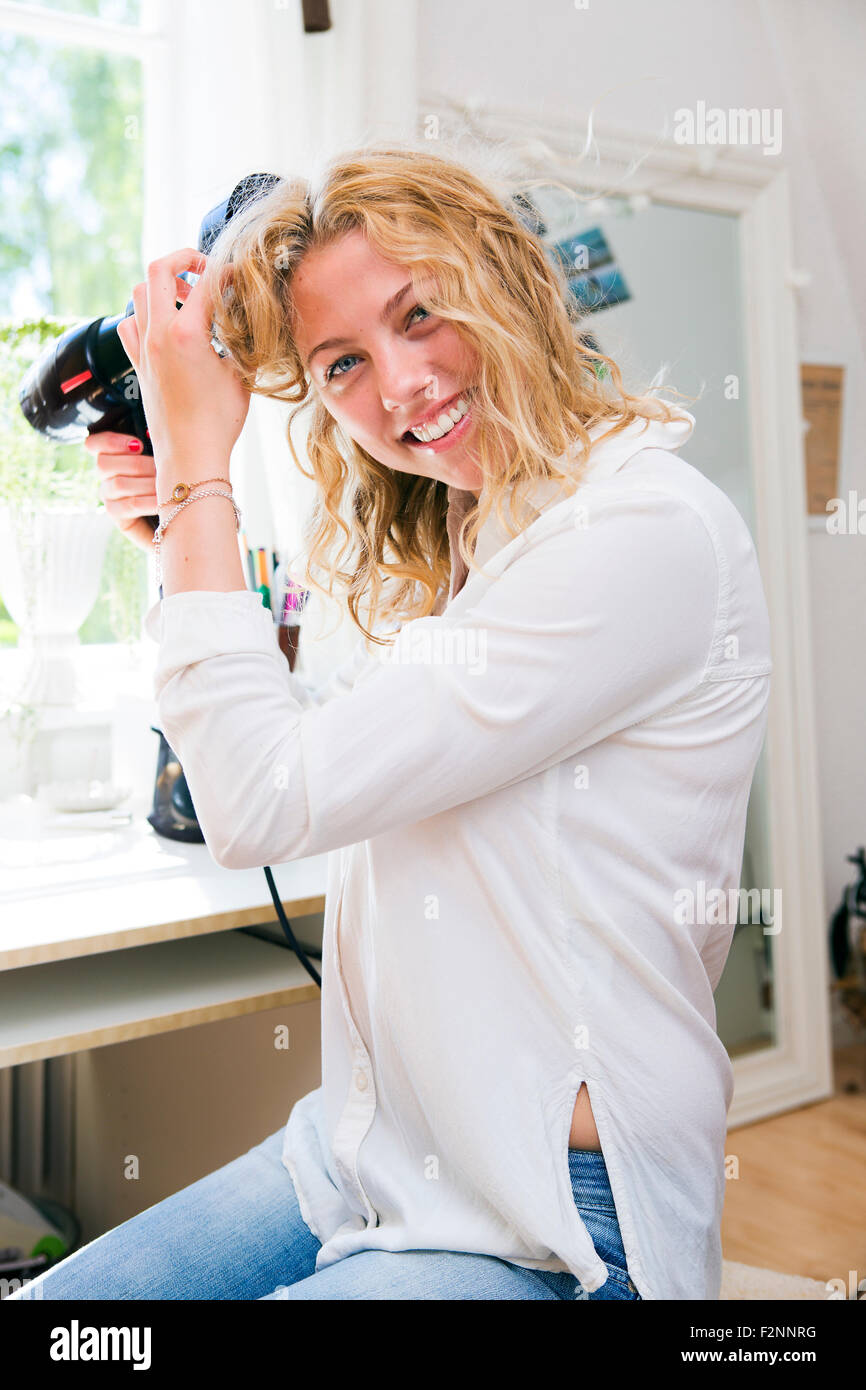 Woman drying her hair in bedroom Stock Photo - Alamy
