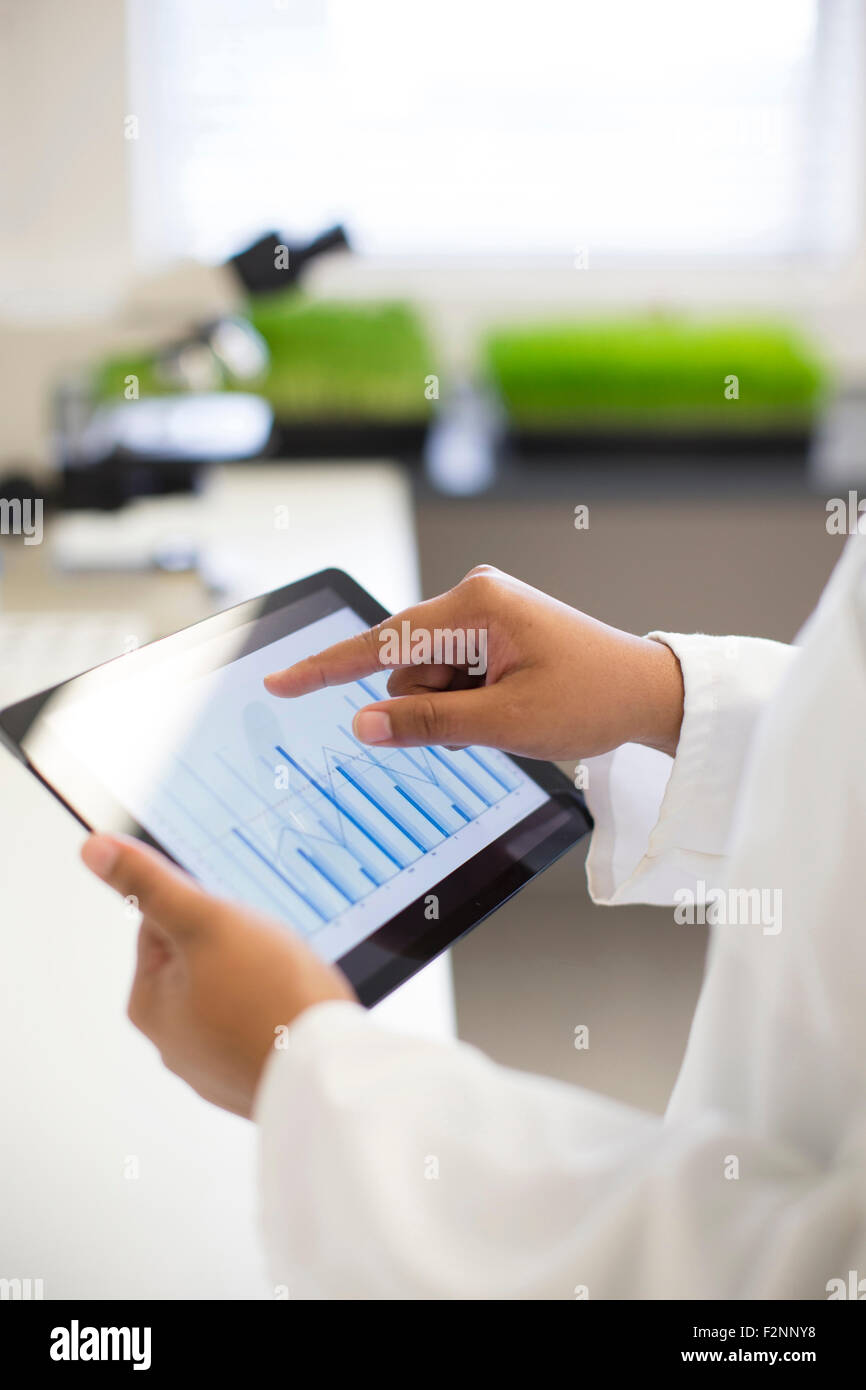 Mixed race scientist using digital tablet in laboratory Stock Photo