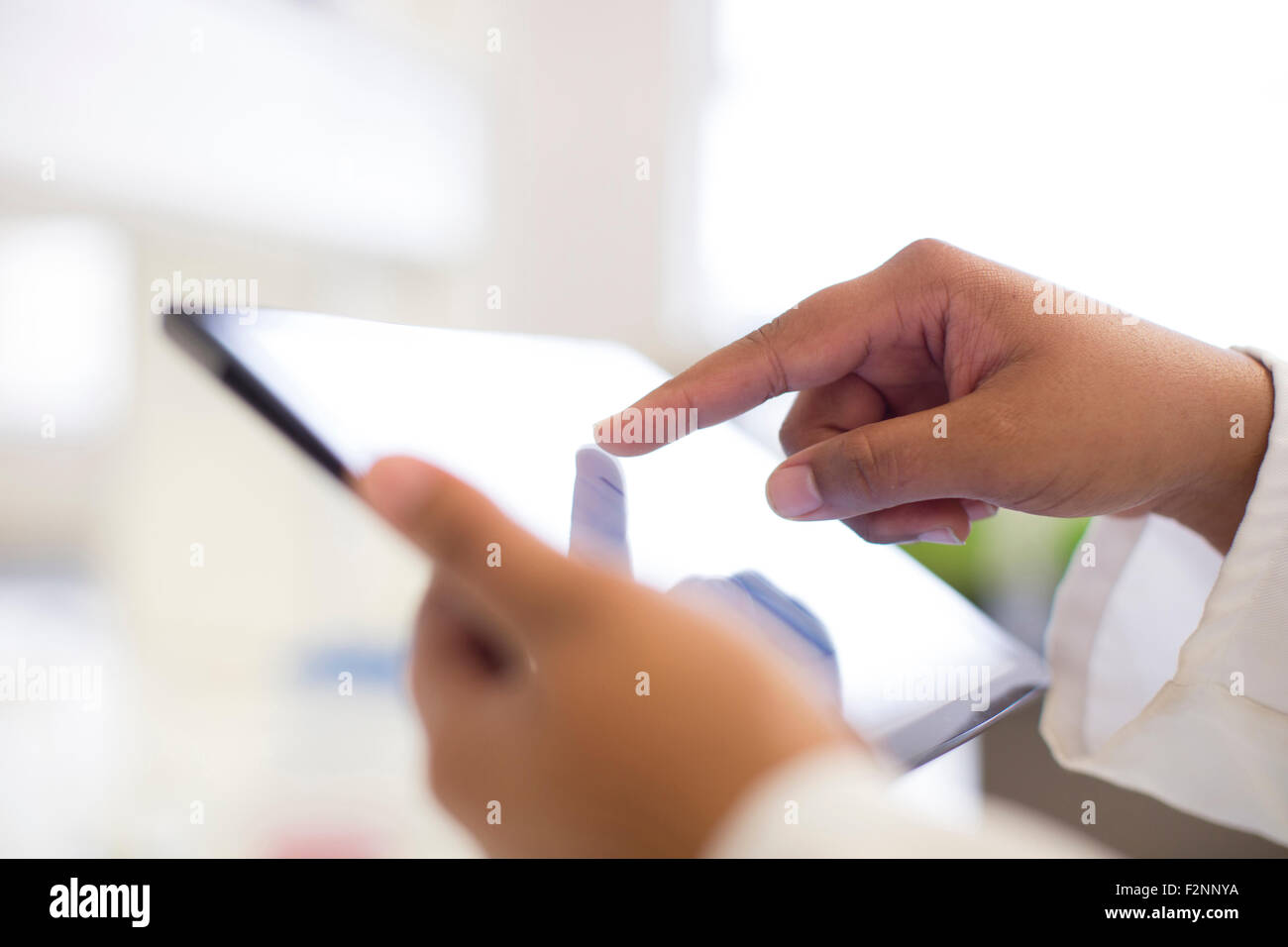 Mixed race scientist using digital tablet in laboratory Stock Photo
