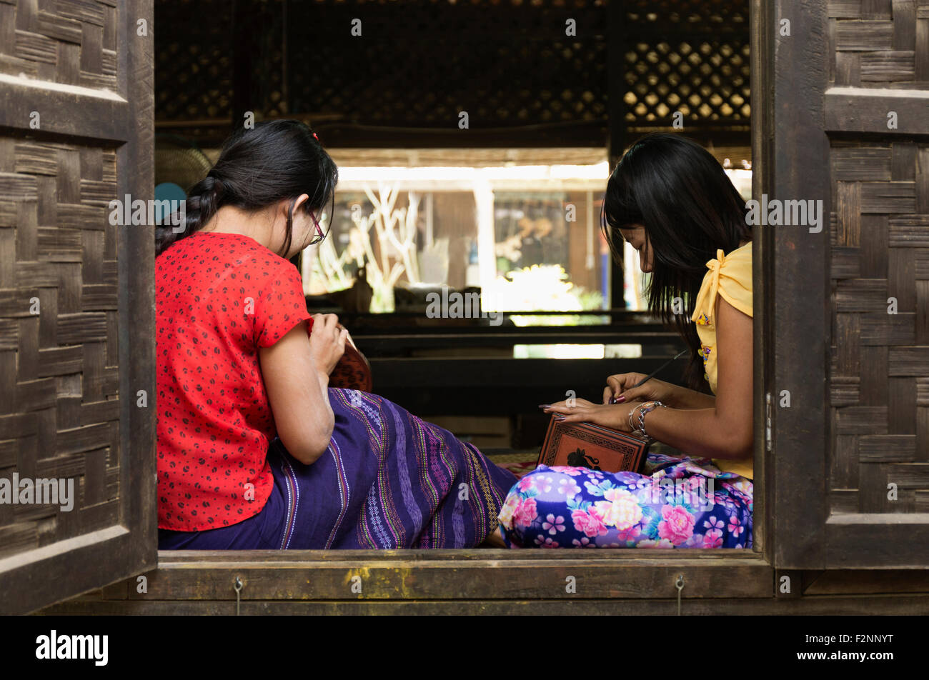 Asian artisans carving traditional design in workshop Stock Photo