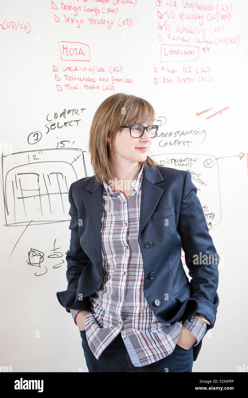 Businesswoman standing at whiteboard in office Stock Photo
