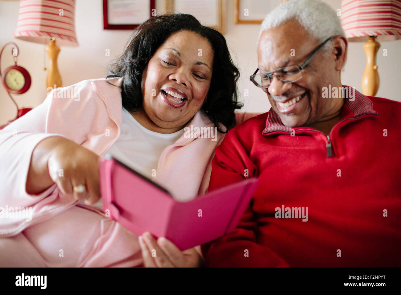 Couple using cell phone in living room Stock Photo