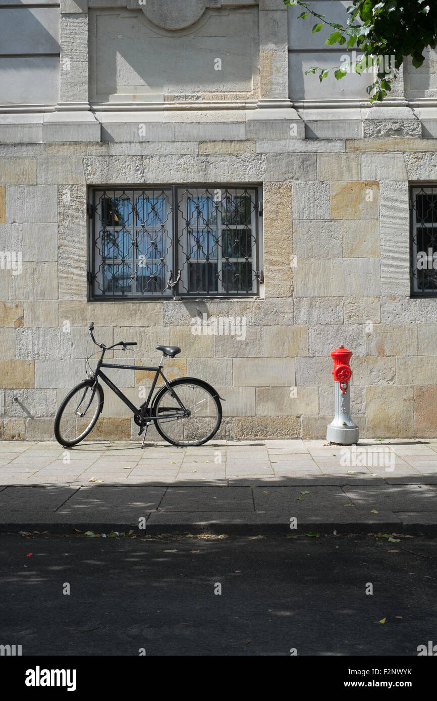 Bicycle parked next to a red and silver fire hydrant outside the stone walled entrance building of the Copenhagen parliament Stock Photo