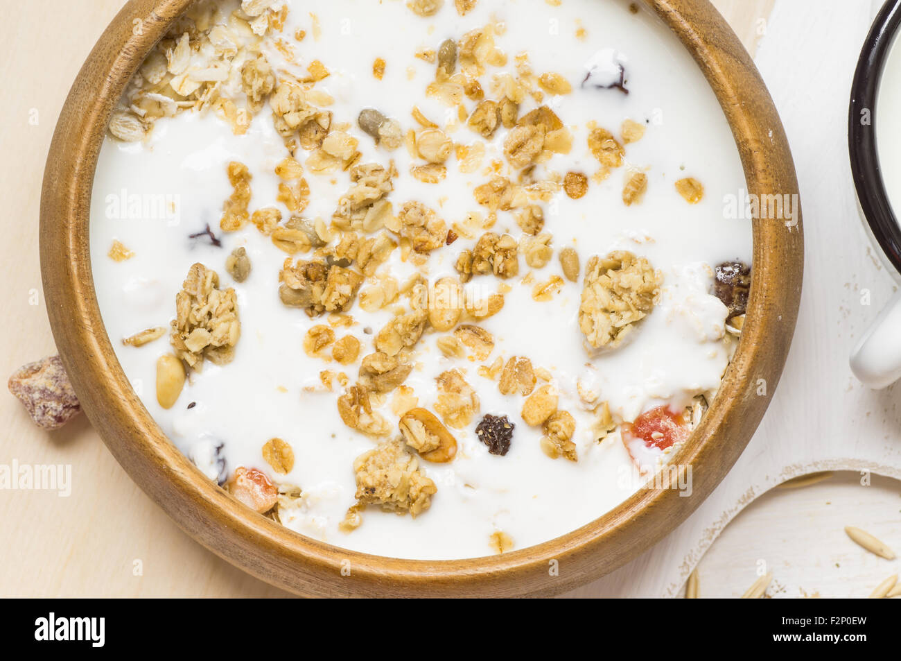 Muesli with fruit and nuts and milk in a wooden bowl rustic style Stock