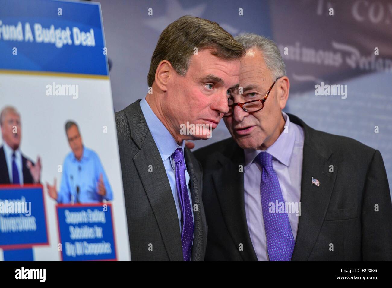 U.S. Senators Chuck Schumer speaks with Senator Mark Warner during a press conference calling for Republicans to support tax loophole closures to help finance a budget agreement on Capitol Hill September 17, 2015 in Washington, DC. Stock Photo