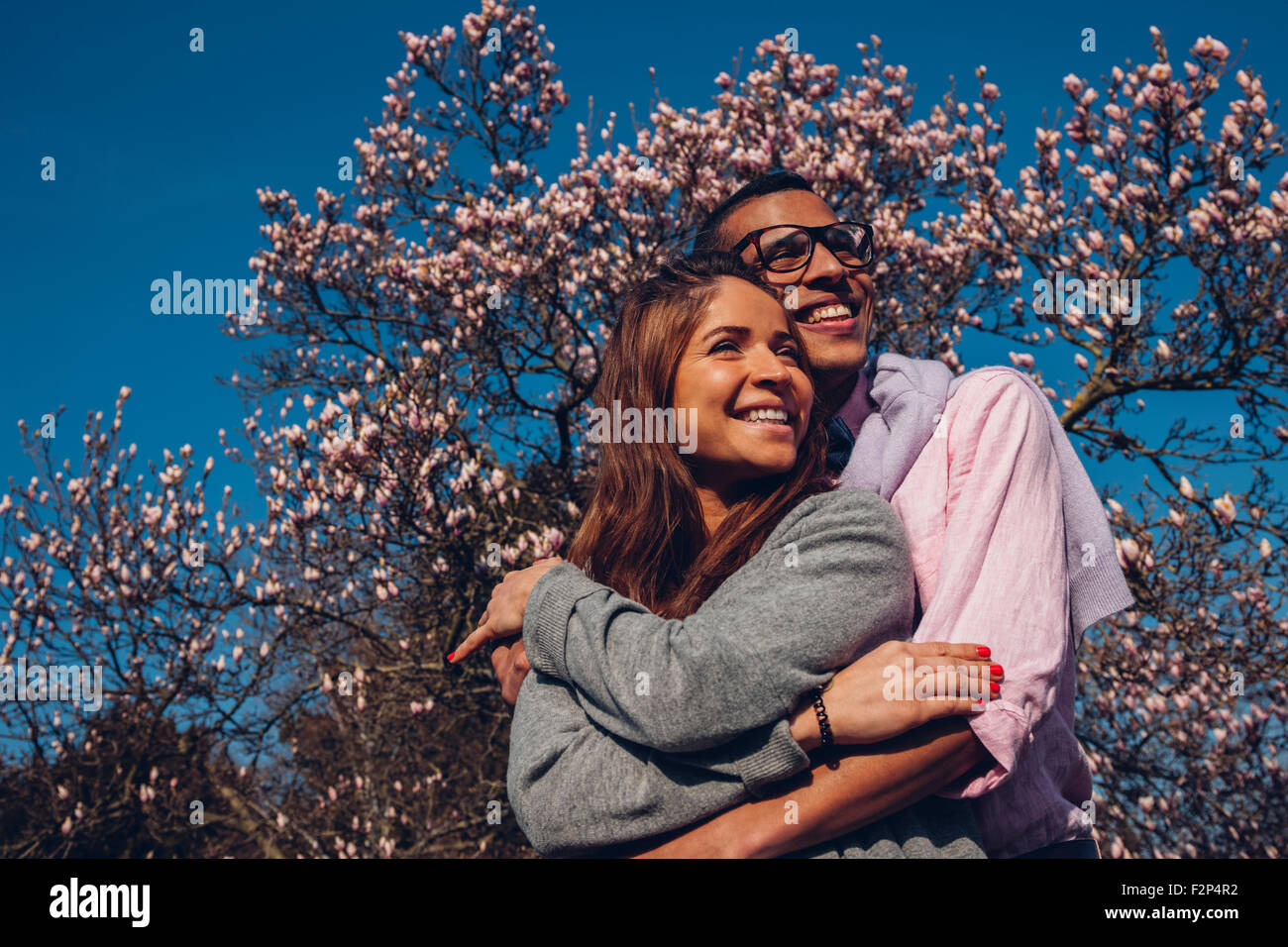 Happy young couple embracing in park Stock Photo - Alamy