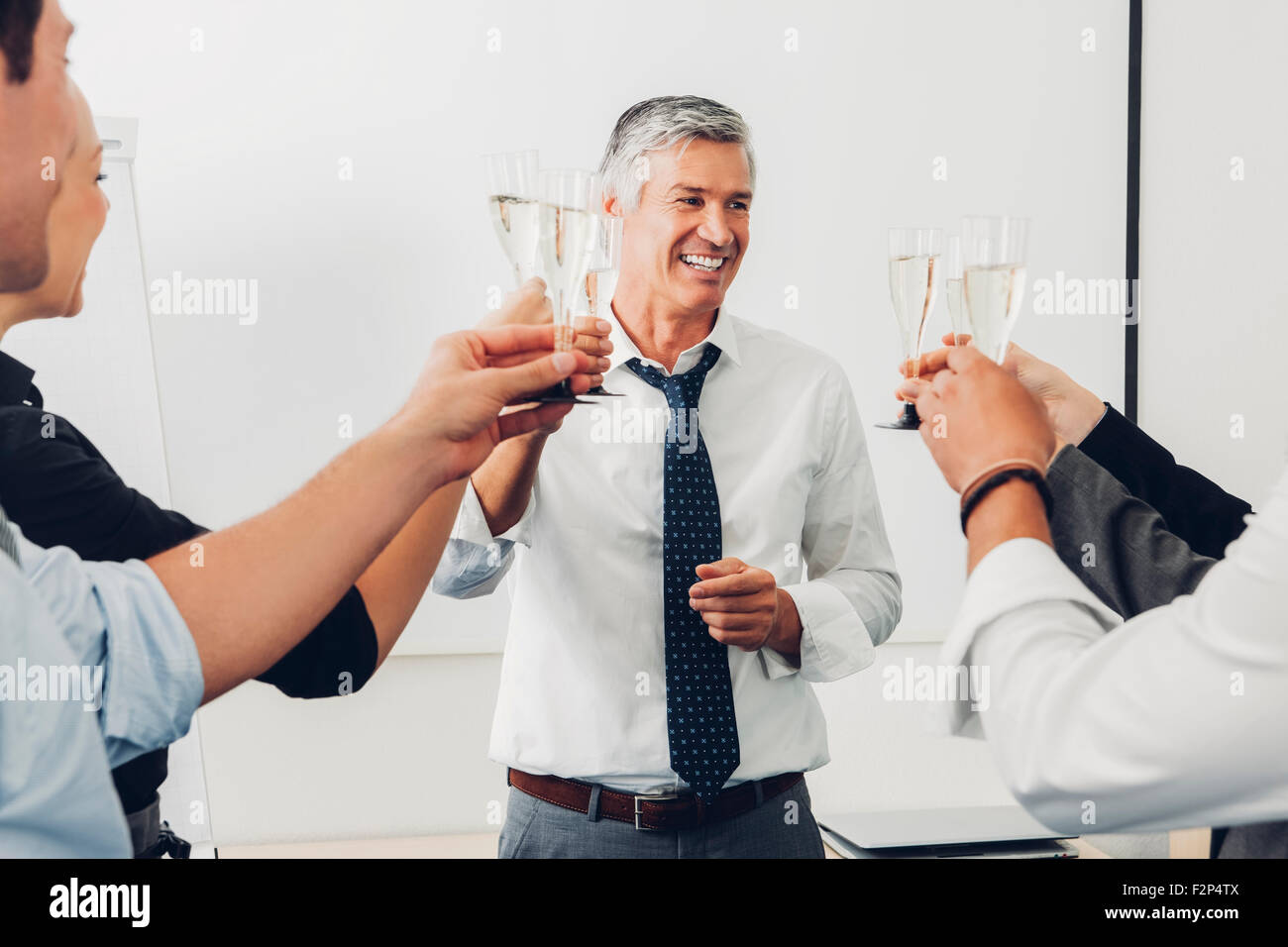 Group of business people raising a toast with champagne at office Stock