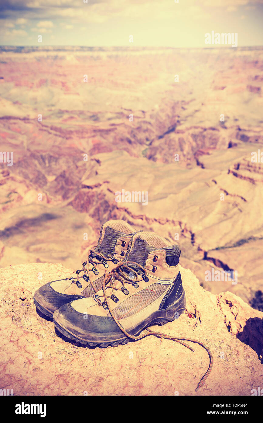 Vintage toned old trekking shoes standing on south rim of Grand Canyon, adventure concept photo. Stock Photo