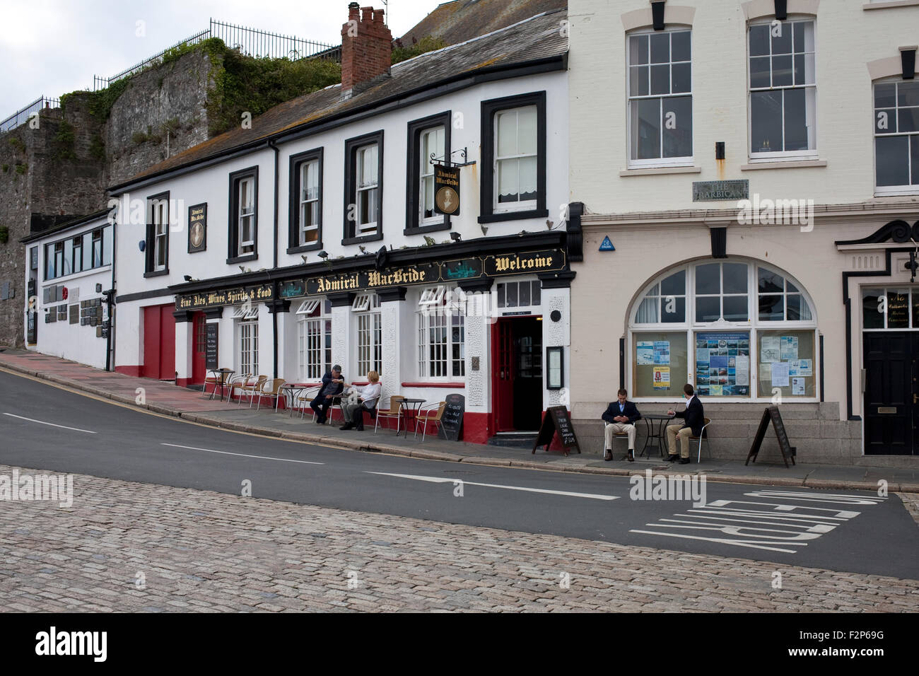 people seated outside the admiral MacBride public house in Sutton Harbour, Plymouth, uk Stock Photo