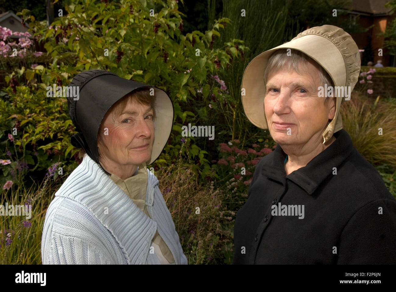 Two female Quaker's (aka Religious Society of Friends) wearing traditional hats outside their meeting house, Alton, Hampshire, UK. Stock Photo
