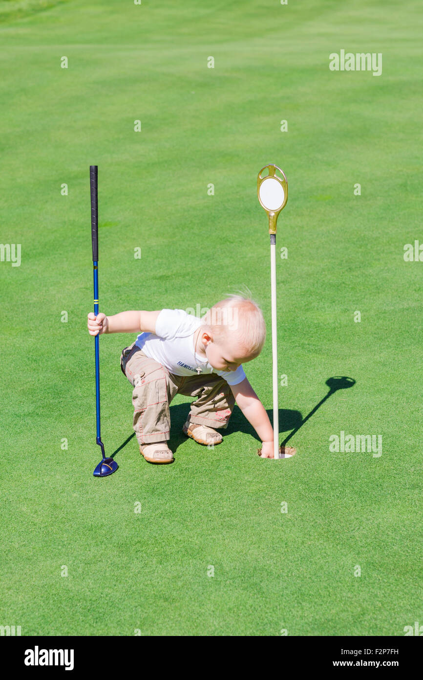 Cute little baby boy playing golf on a field outdoor Stock Photo - Alamy
